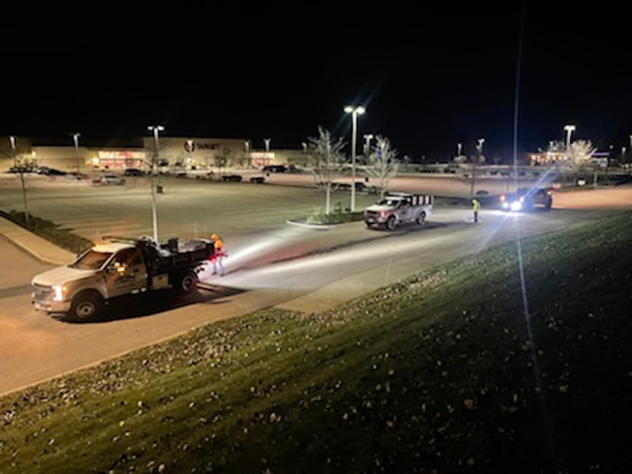 Equipment cleaning a commercial parking area at night