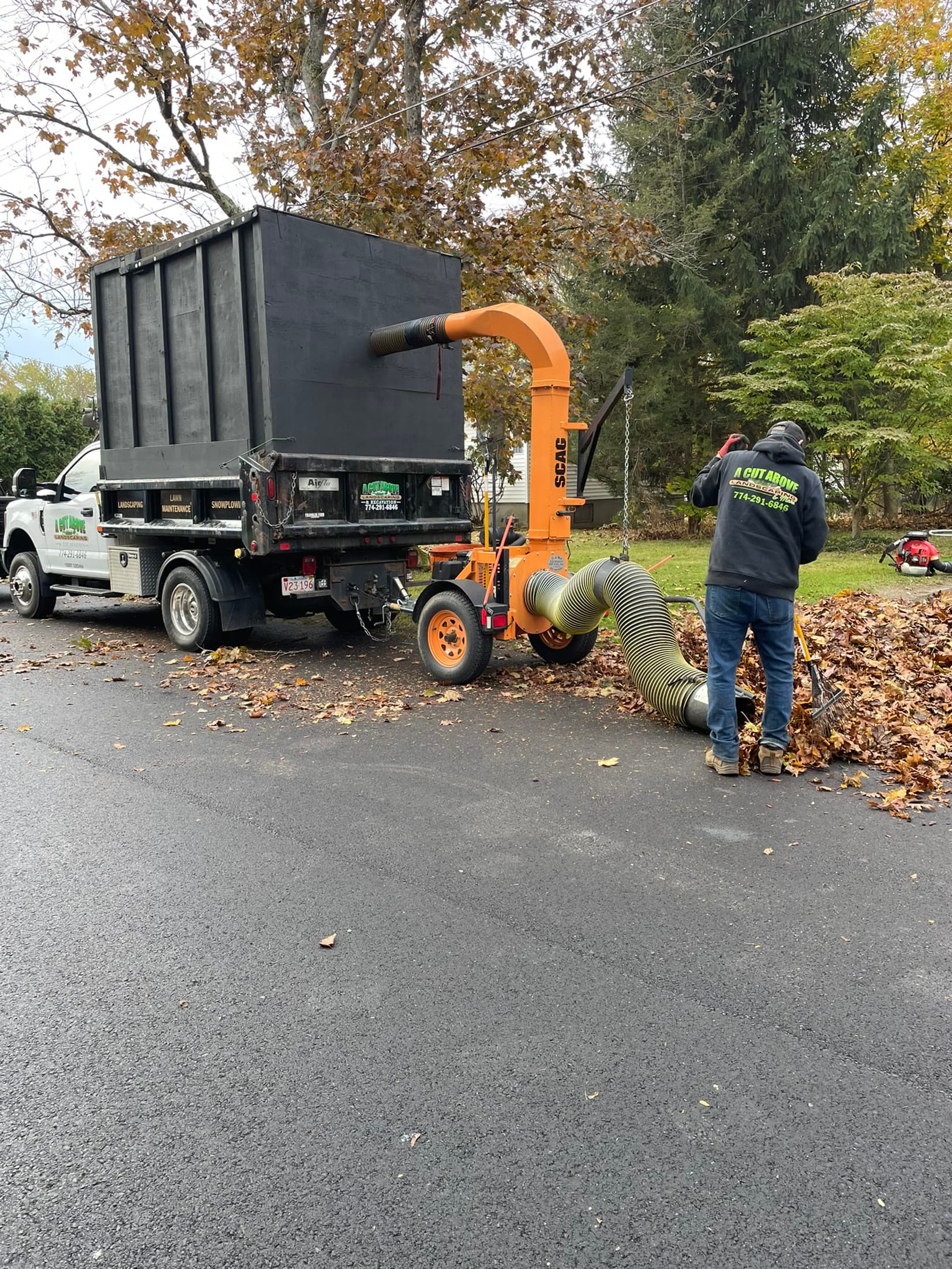 Landscape crew clearing fallen leaves from a residential lawn
