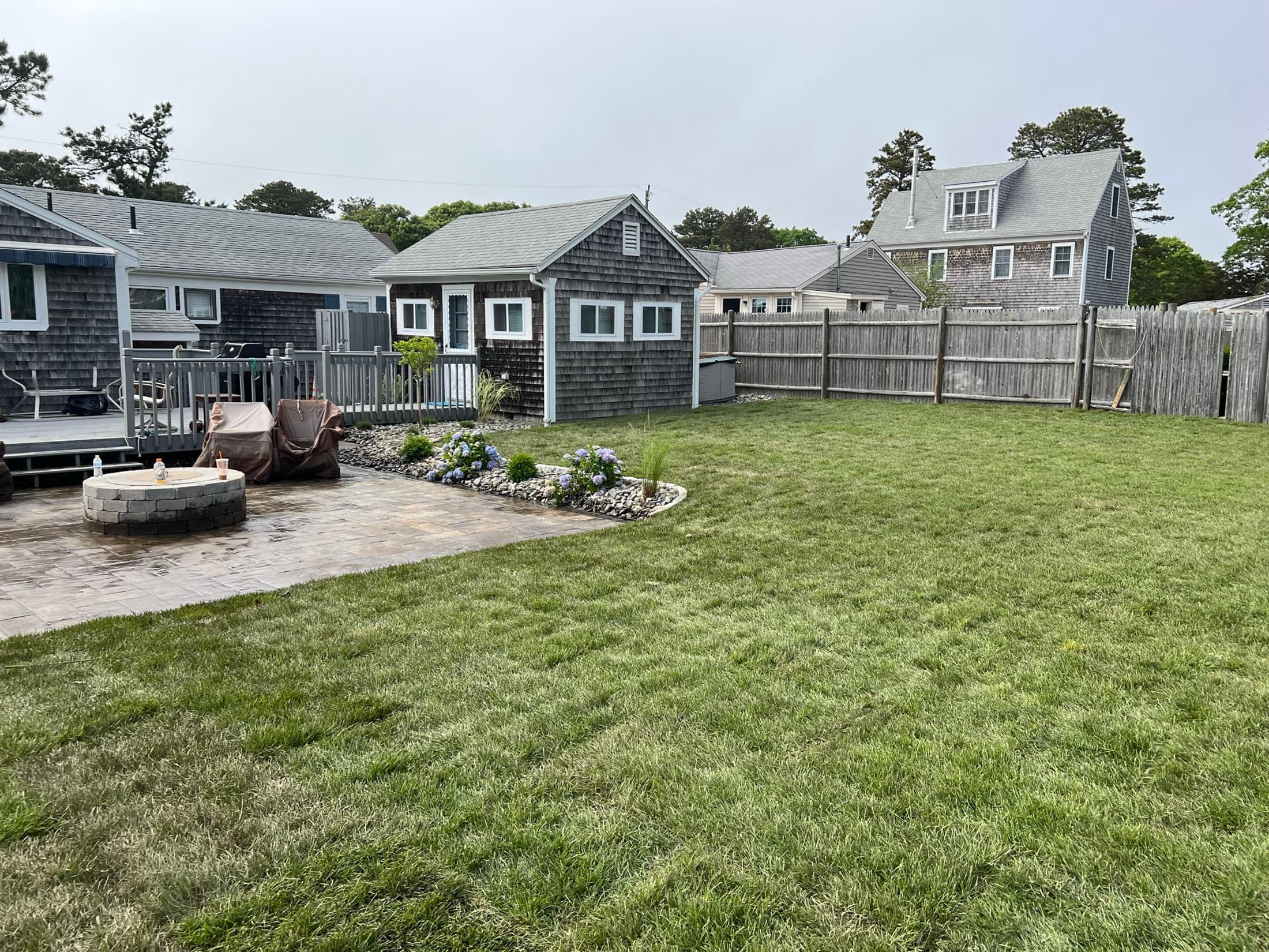 Completed backyard lawn beside a patio and circular fire area