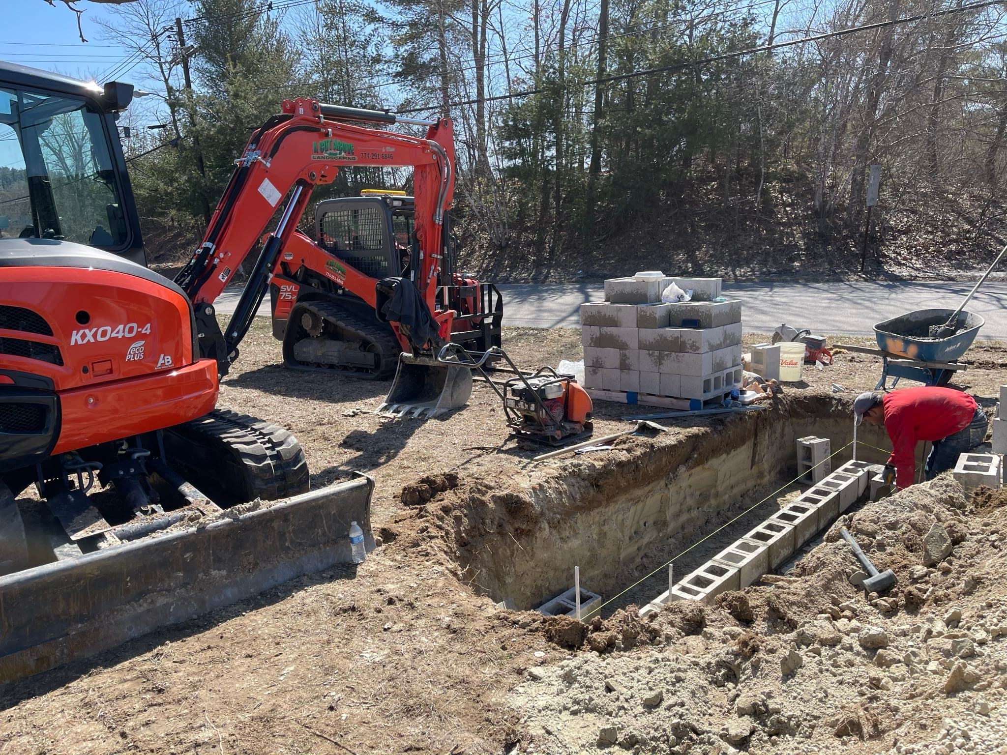 Compact excavators supporting foundation and block work on an active site