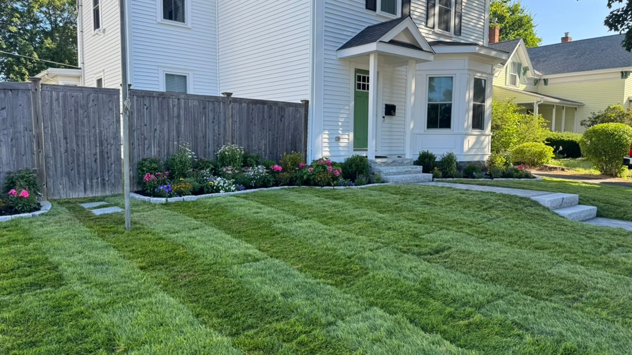 New front lawn beside a finished residential walkway and planting beds