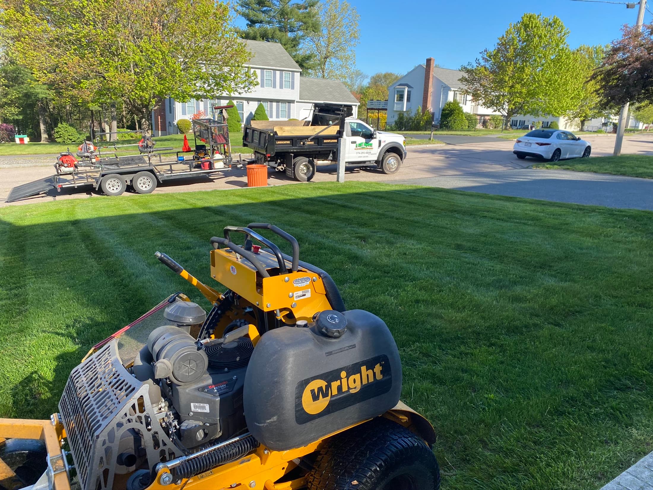 Professional mower and maintenance equipment working on a residential lawn