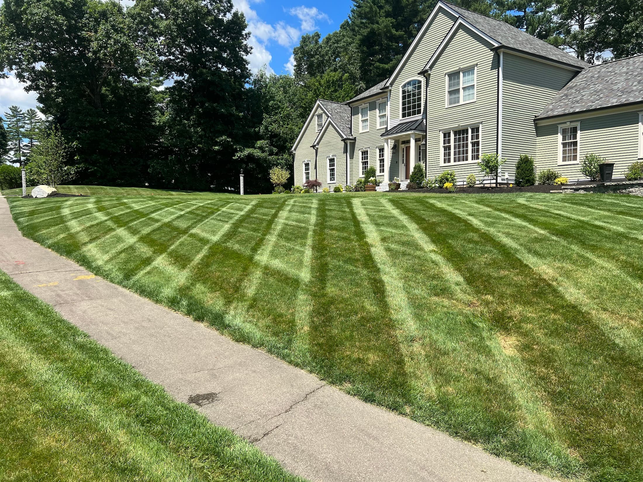 Professionally maintained residential lawn with crisp stripes and finished planting beds