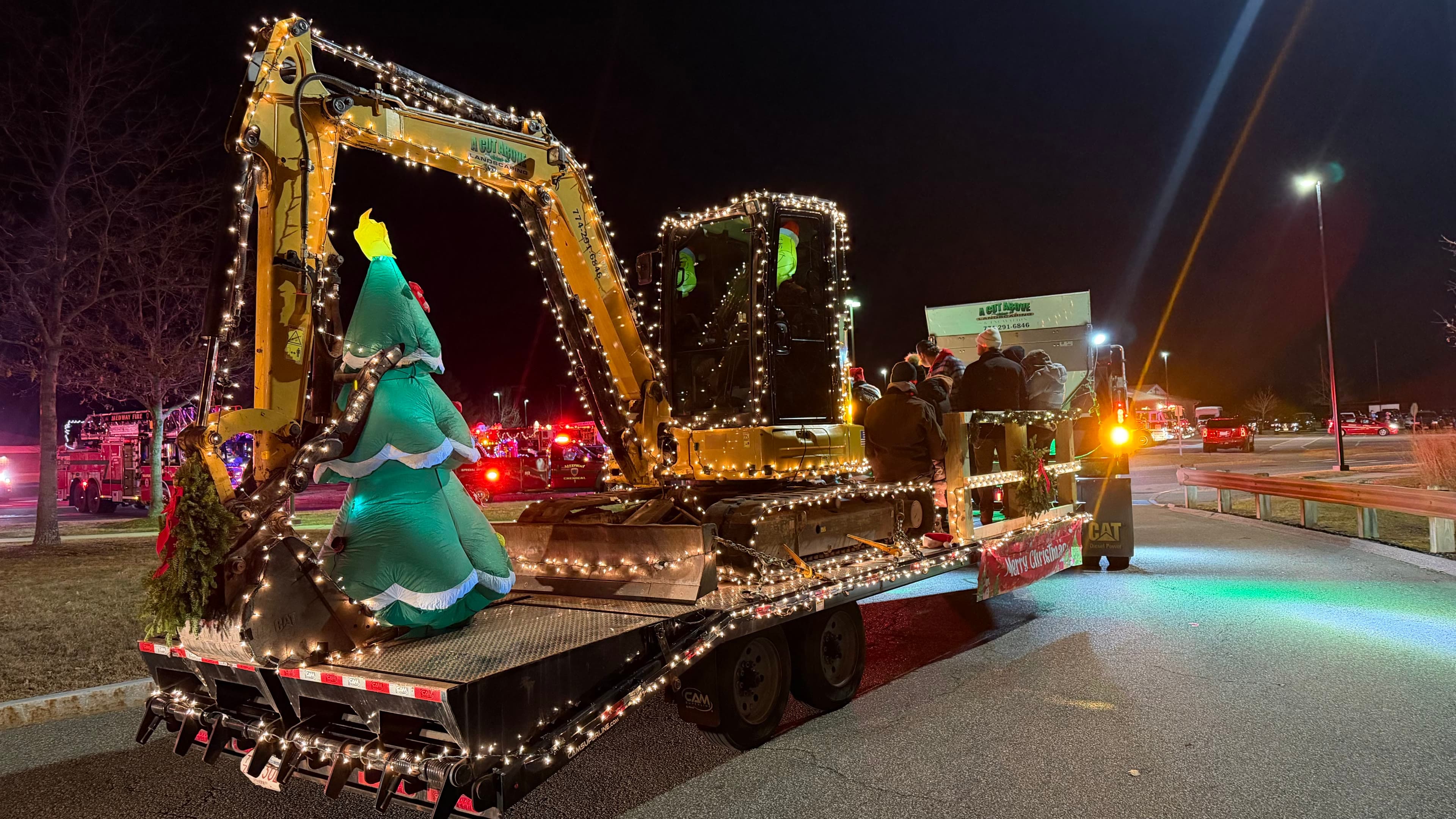 A Cut Above excavator and equipment float covered in holiday lights for the Bellingham and Medway Christmas parades