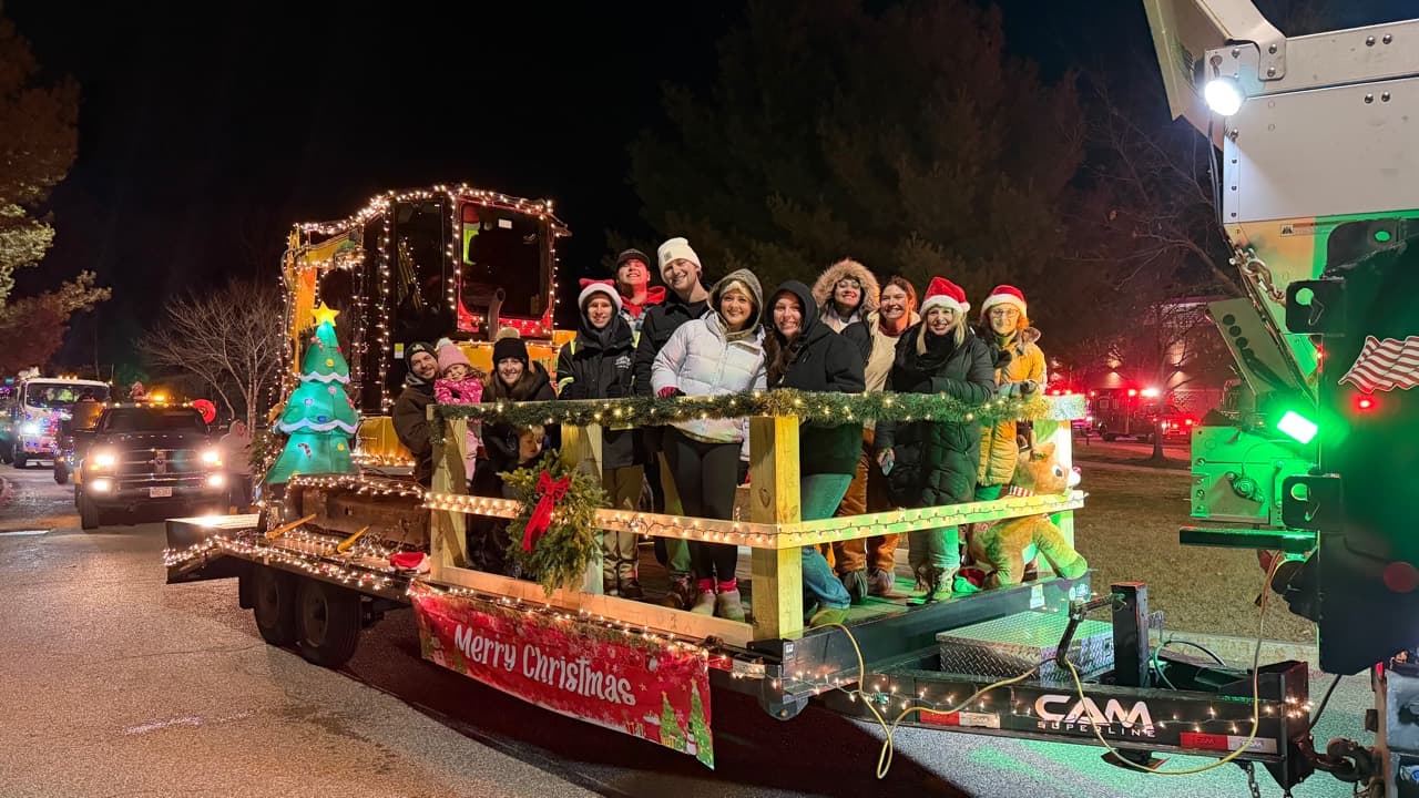 A Cut Above team and families riding a decorated float in the Bellingham and Medway Christmas parades